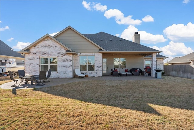 rear view of house with a patio, a lawn, fence, and a fire pit