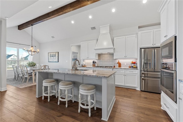 kitchen with visible vents, premium range hood, lofted ceiling with beams, a sink, and stainless steel appliances