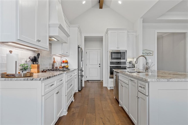 kitchen featuring wood finished floors, custom exhaust hood, stainless steel appliances, white cabinetry, and tasteful backsplash