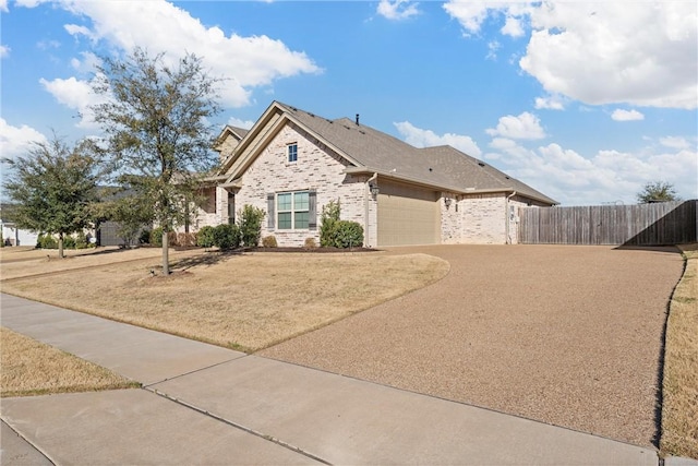 view of front facade featuring a front lawn, driveway, fence, a garage, and brick siding