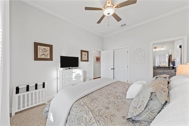 carpeted bedroom with visible vents, ensuite bathroom, a ceiling fan, crown molding, and baseboards