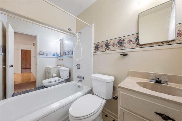 full bathroom featuring vanity, tiled shower / bath, and toilet