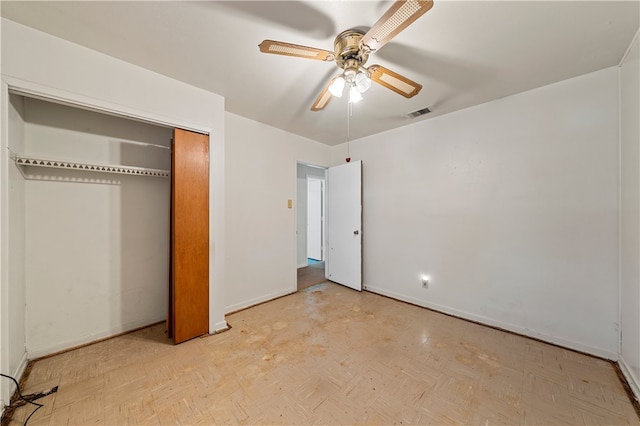 unfurnished bedroom with ceiling fan, light parquet flooring, and a closet