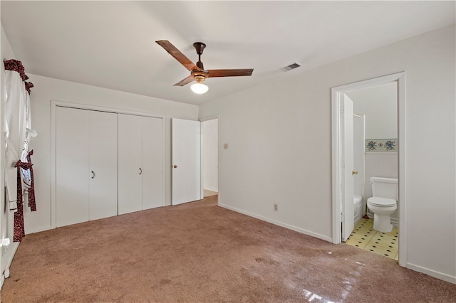 unfurnished bedroom with light carpet, a closet, ensuite bathroom, and ceiling fan