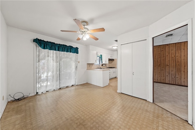 interior space featuring wood walls, sink, and ceiling fan