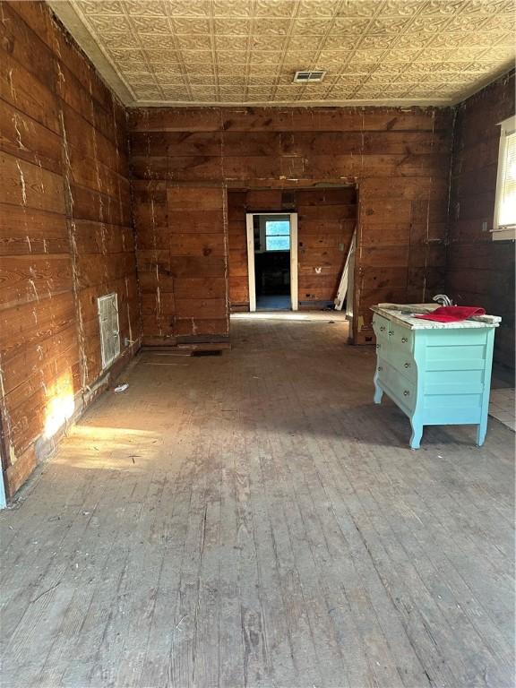 misc room with hardwood / wood-style floors, a wealth of natural light, and wooden walls