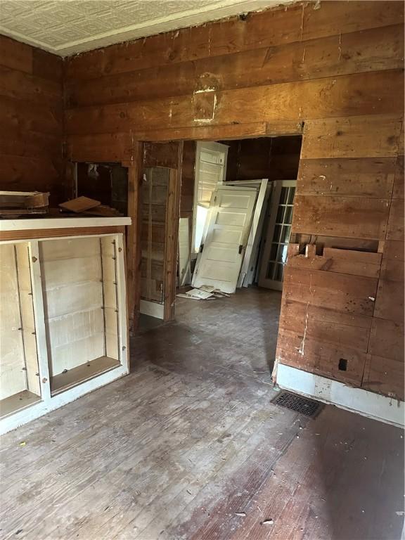 unfurnished room featuring hardwood / wood-style floors and wood walls