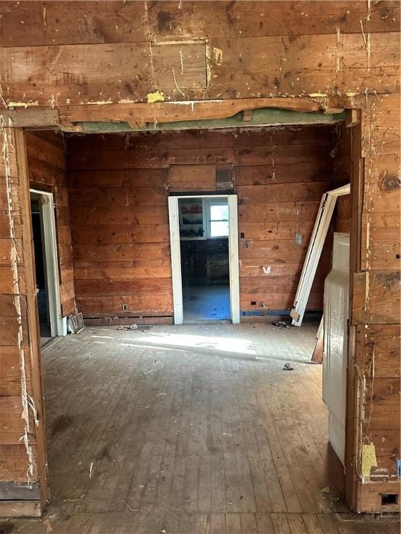 misc room featuring hardwood / wood-style floors and wood walls