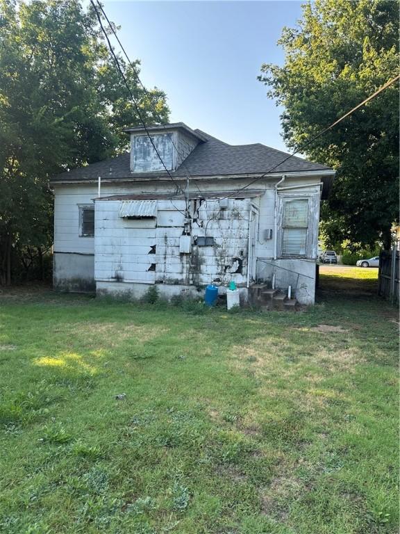 rear view of property featuring a lawn