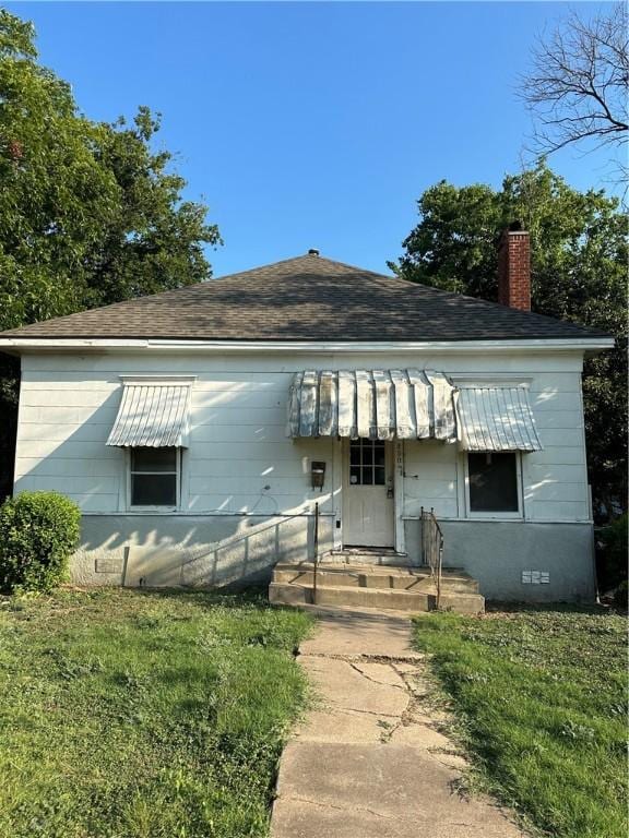 bungalow-style home featuring a front lawn