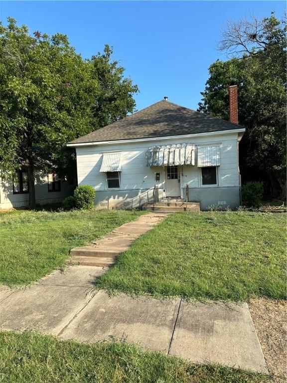 bungalow-style house with a front lawn