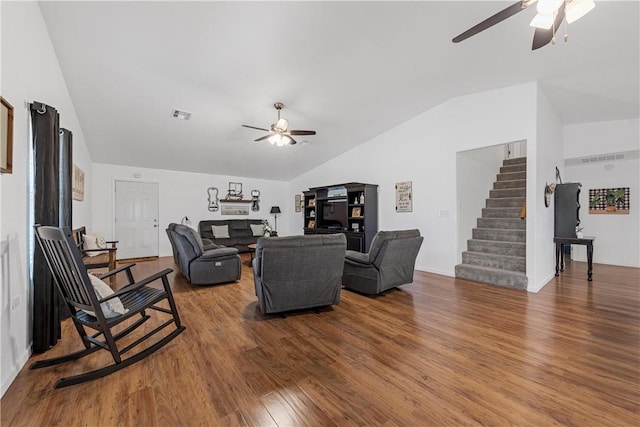 living area featuring stairway, wood finished floors, visible vents, lofted ceiling, and ceiling fan