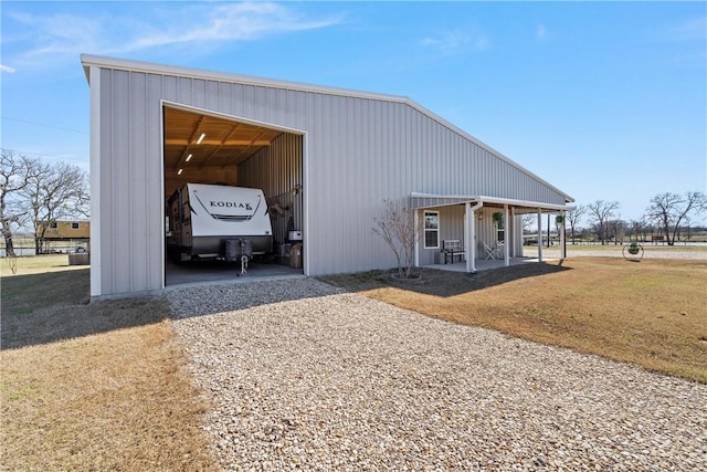 view of pole building with a lawn and driveway