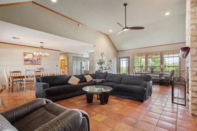 living room featuring a fireplace, high vaulted ceiling, ceiling fan with notable chandelier, and light tile patterned floors