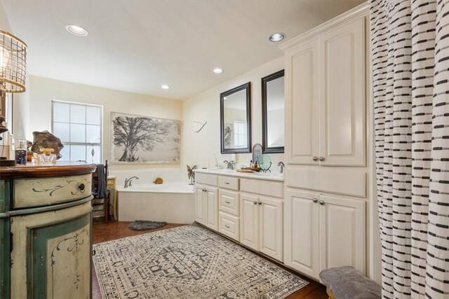 bathroom with vanity, hardwood / wood-style flooring, and a bathing tub