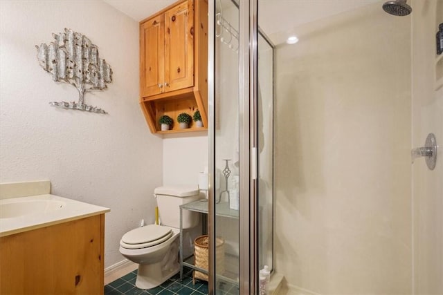 bathroom with vanity, toilet, and a shower with door