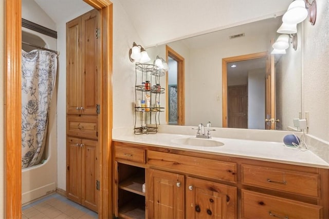 bathroom featuring tile patterned flooring, shower / bath combination with curtain, vanity, and vaulted ceiling