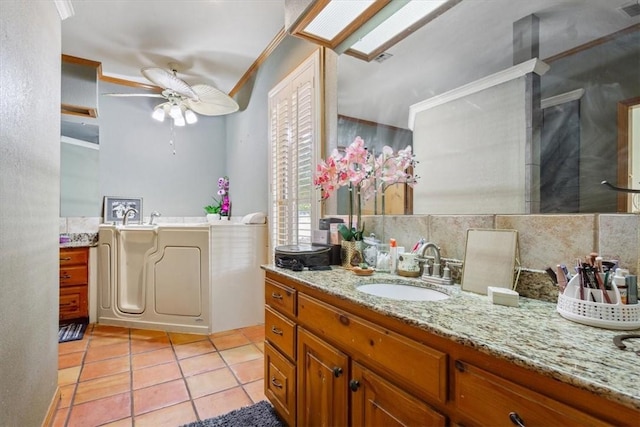 bathroom featuring tile patterned flooring, ceiling fan, vanity, and tasteful backsplash