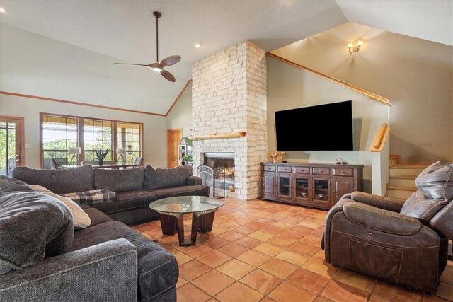 living room with a fireplace, light tile patterned floors, high vaulted ceiling, and ceiling fan