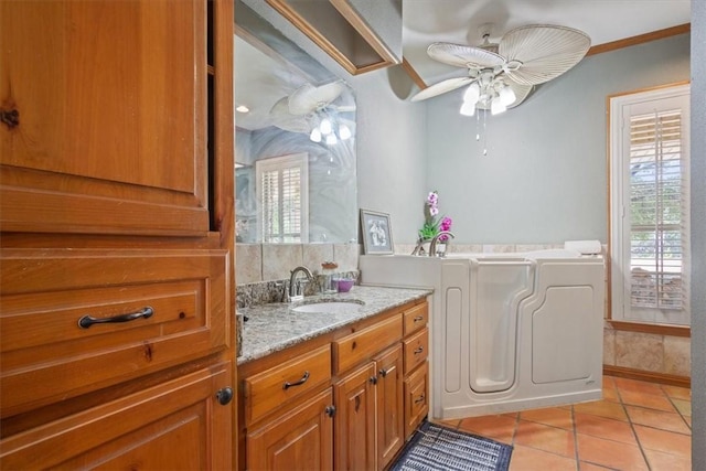 bathroom with ceiling fan, tile patterned floors, crown molding, a bathtub, and vanity