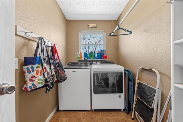 laundry area with washer and clothes dryer, laundry area, a textured ceiling, and a textured wall