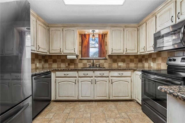 kitchen with black electric range oven, a sink, dark stone countertops, tasteful backsplash, and dishwasher