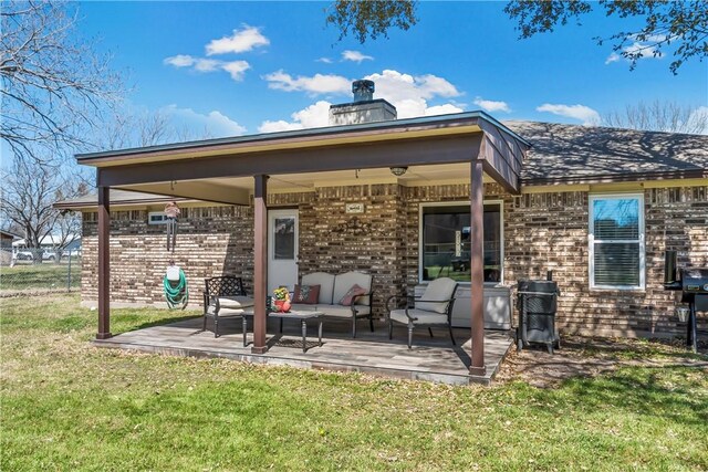 rear view of house with brick siding, a lawn, a chimney, and outdoor lounge area