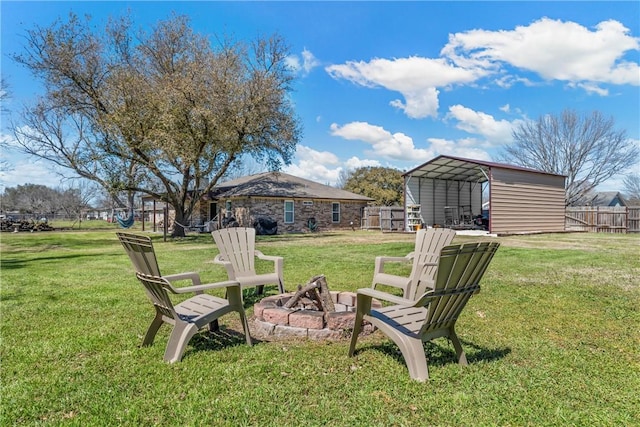 view of yard featuring a fire pit, a carport, and fence