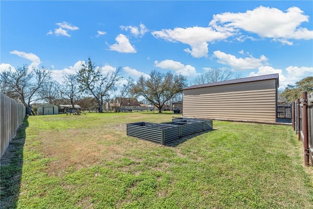 view of yard featuring an outbuilding, a fenced backyard, and a storage shed