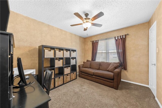 carpeted office space featuring ceiling fan, baseboards, and a textured ceiling