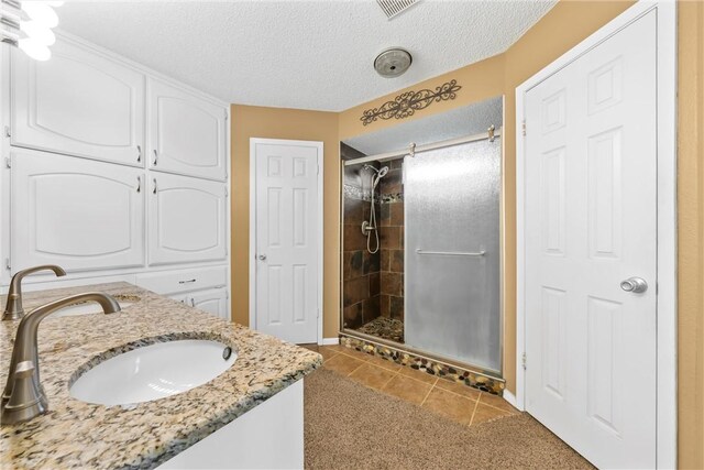 full bathroom with tile patterned flooring, visible vents, a stall shower, and a textured ceiling