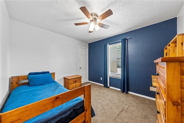 bedroom with baseboards, a textured ceiling, ceiling fan, and carpet flooring