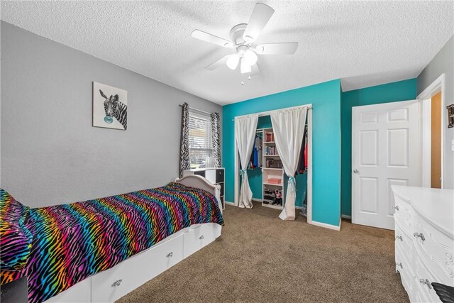 carpeted bedroom with a closet, baseboards, a textured ceiling, and ceiling fan