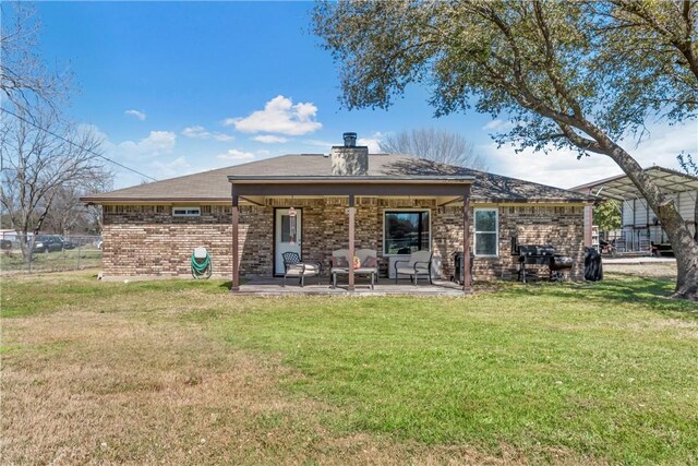 back of property featuring a patio area, fence, a lawn, and brick siding