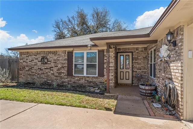 entrance to property featuring brick siding