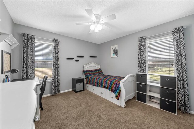 bedroom with ceiling fan, baseboards, carpet floors, and a textured ceiling