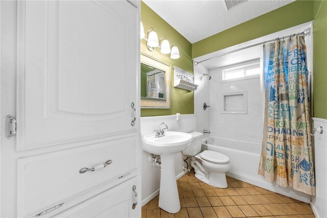 full bath featuring visible vents, toilet, shower / bath combo, tile patterned floors, and a textured ceiling