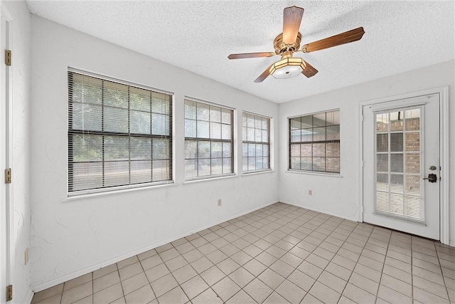 unfurnished sunroom with ceiling fan