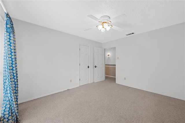 empty room with a textured ceiling and ceiling fan