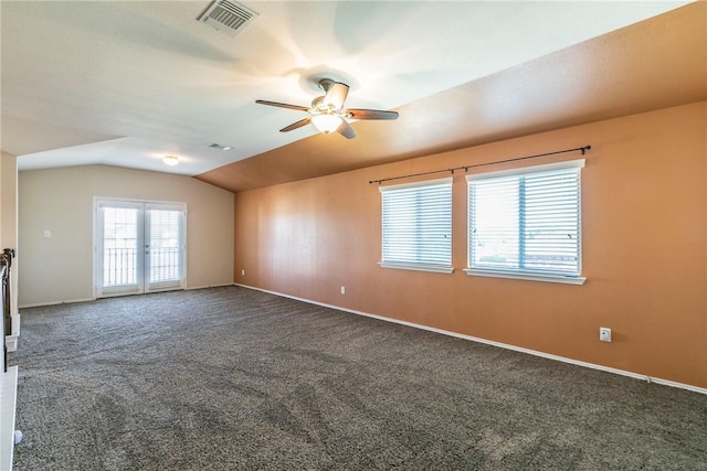 empty room featuring french doors, dark carpet, ceiling fan, and lofted ceiling