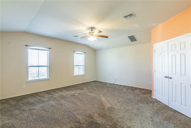 unfurnished bedroom featuring ceiling fan, dark carpet, and vaulted ceiling