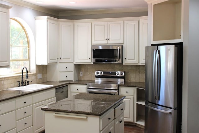 kitchen with white cabinetry, a center island, stainless steel appliances, and sink