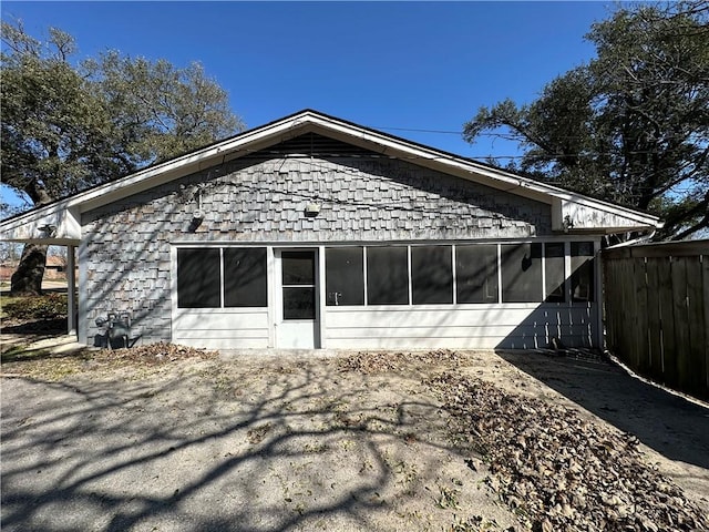 back of house with a sunroom and fence