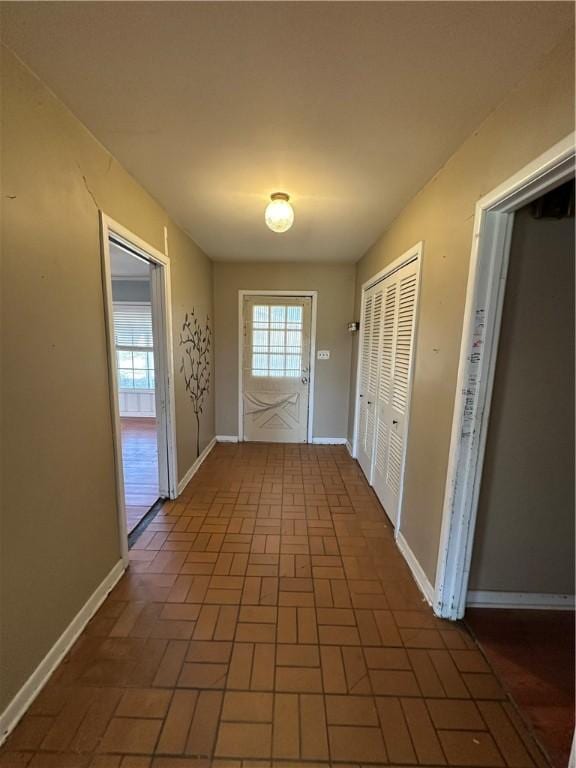 entryway with brick floor and baseboards