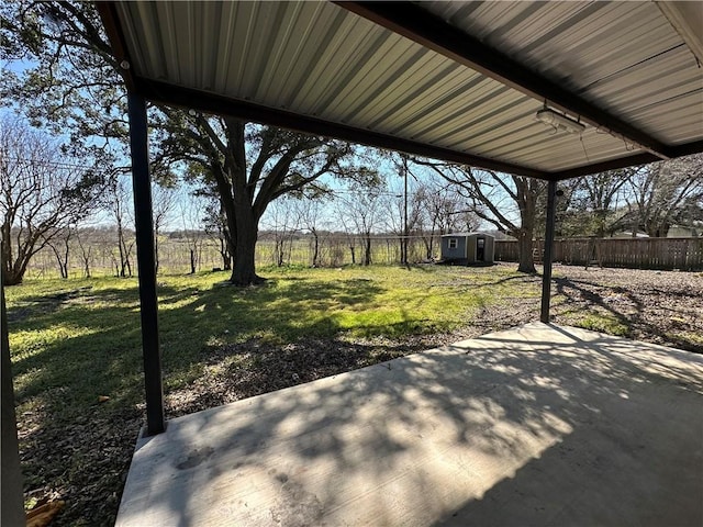 view of patio featuring an outbuilding, a storage unit, and a fenced backyard