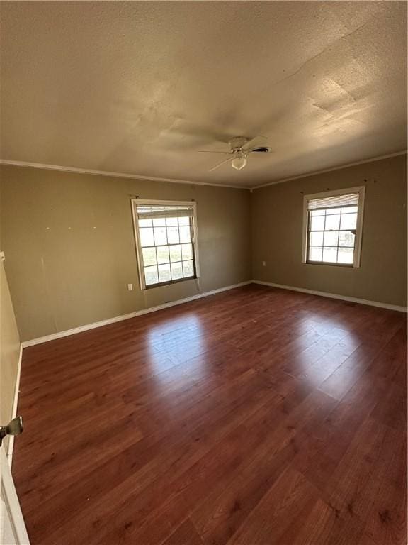 spare room featuring ceiling fan, dark wood-style flooring, plenty of natural light, and baseboards