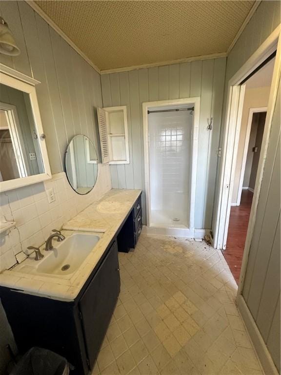 full bath featuring a stall shower, ornamental molding, and vanity