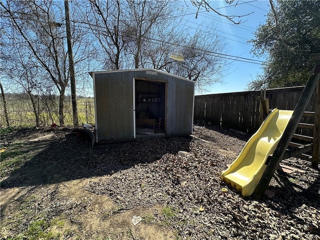 view of shed featuring fence and a playground