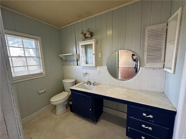 bathroom featuring backsplash, crown molding, vanity, and toilet