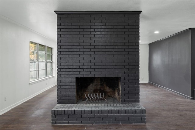 interior details featuring crown molding, wood-type flooring, and a brick fireplace